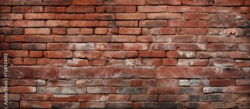Detailed view of a aged brick wall containing a small window, showing the texture and structure of the bricks