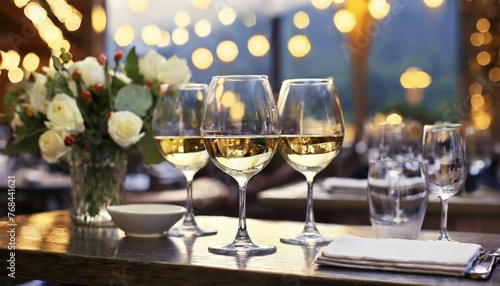 glasses of champagne on table, wallpaper Glasses of white wine served on table in restaurant © Bilawl