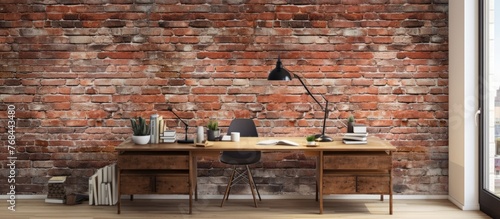 Desk and sleek lamp placed against a textured brick wall, creating a simple yet functional workspace