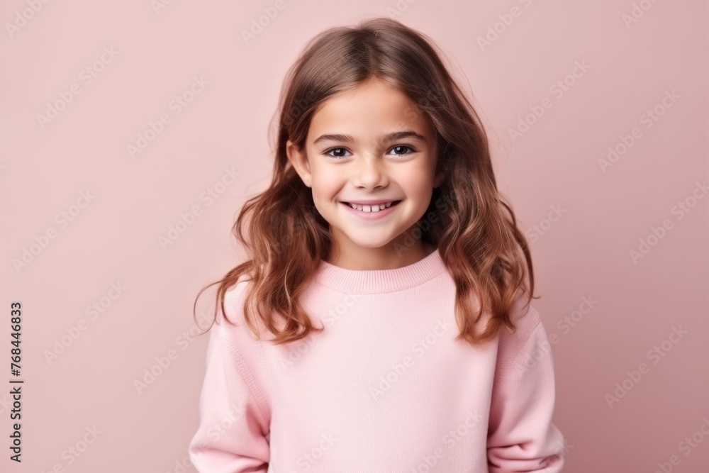 Portrait of a smiling little girl in a pink sweater on a pink background Portrait of a smiling little girl in a pink sweater on a pink background