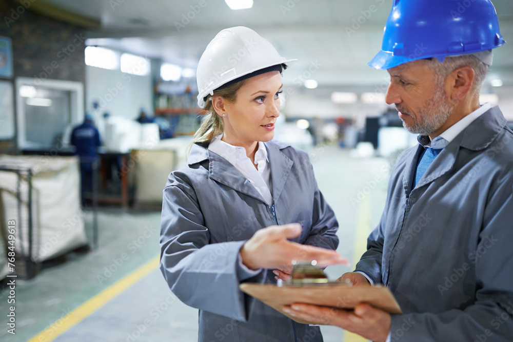 Man, woman and conversation with clipboard in warehouse for quality inspection or safety checks and process monitoring. Team, communication and board for manufacturing information in printing factory Man, woman and conversation with clipboard in warehouse for quality inspection or safety checks and process monitoring. Team, communication and board for manufacturing information in printing factory