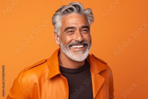 Portrait of happy mature man in orange jacket on orange background. © Chacmool