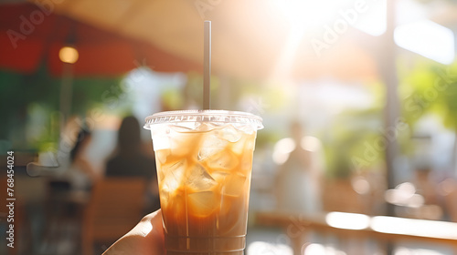 glass of beer on the table, Iced coffee in a togo cup with straw background, A hand holding a cup of iced coffee
