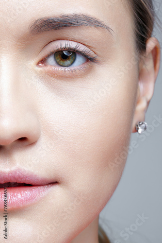 Closeup shot of human female face. Woman with nude makeup of eyes or no makeup.