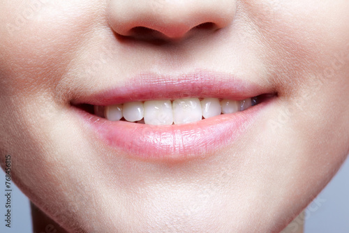 Female human mouth and nose. Macro portrait of smiling woman face with no makeup.