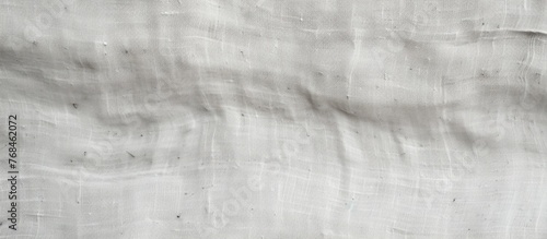 A closeup shot of a white cloth with a textured grey pattern. The monochrome photography captures the tints and shades of the fabric, resembling wood flooring