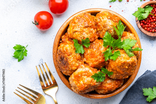 Meatballs with tomato sauce in bowl on white table background. Top view