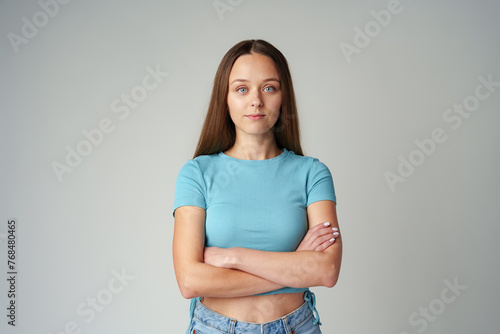 Portrait of smiling young woman in blue T-shirt on gray background