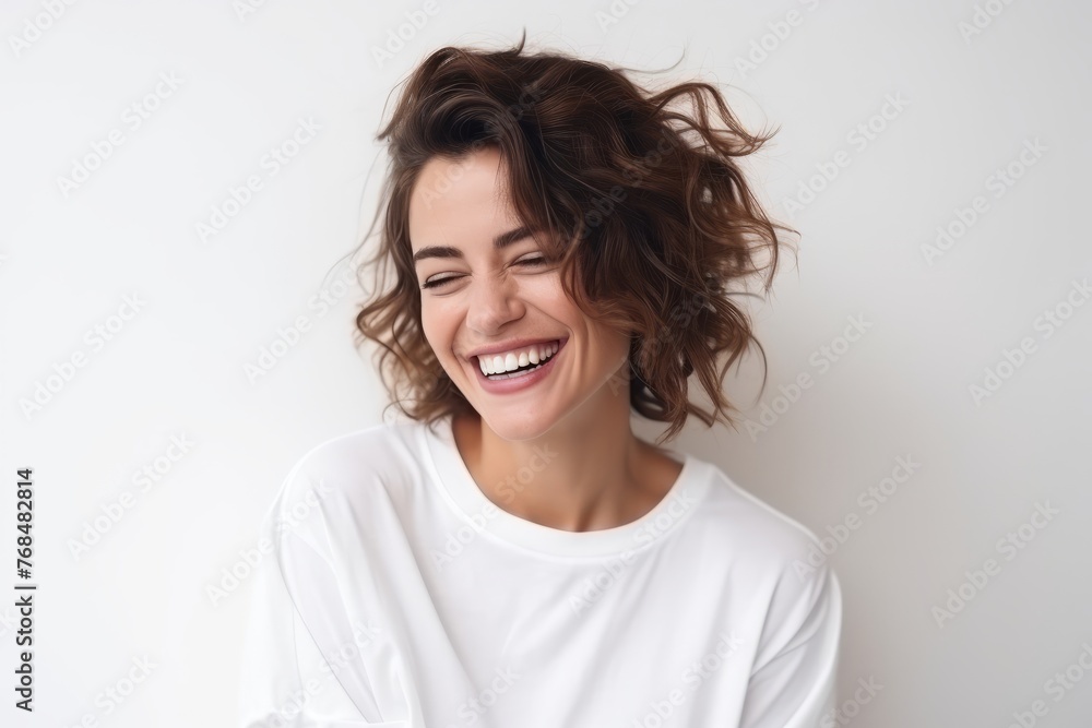 Portrait of a laughing young woman looking at camera over white background Portrait of a laughing young woman looking at camera over white background