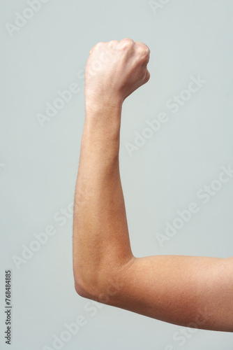 Male clenched fist on gray background close up