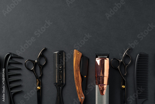 An Assortment of Professional Hairdressing Tools Laid Out on a Dark Surface