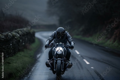 Motorcyclist riding on a country road in a foggy day