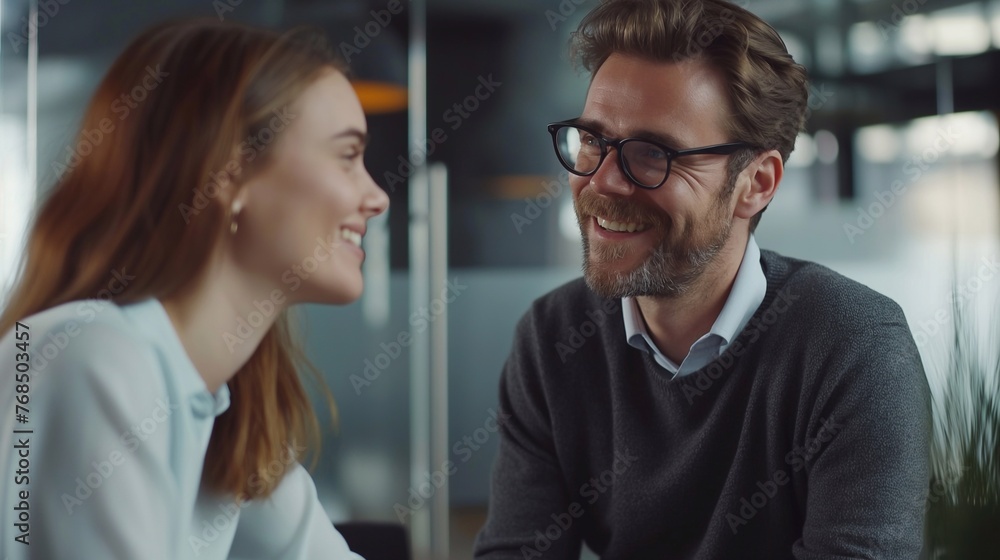 A man and a woman are talking about work issues in the office. Two colleagues at the workplace are discussing a new project. Successful professionals A man and a woman are talking about work issues in the office. Two colleagues at the workplace are discussing a new project. Successful professionals
