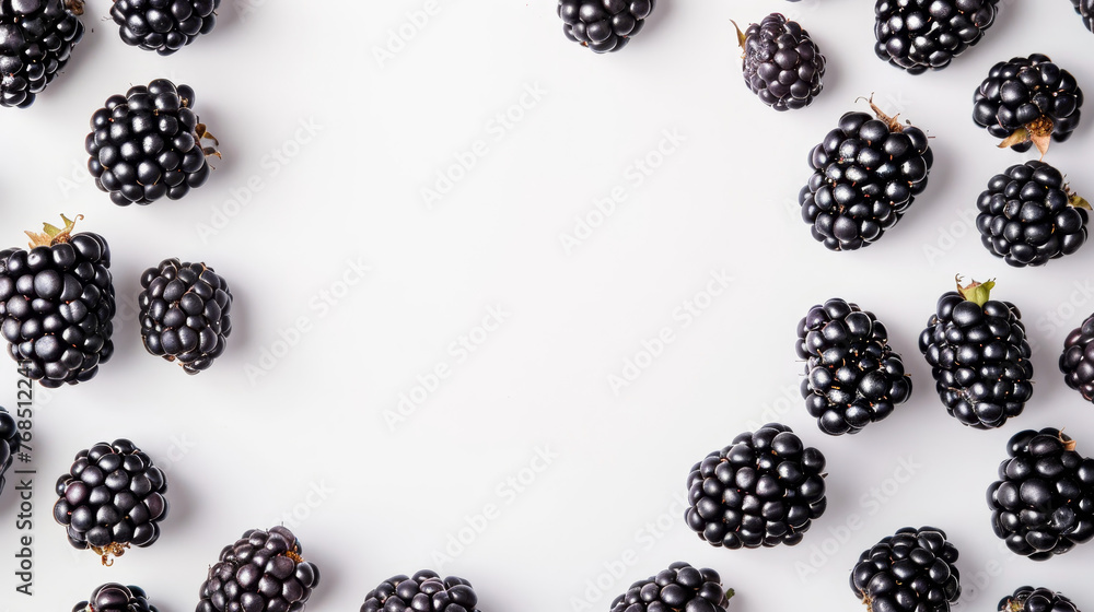 A cluster of juicy blackberries scattered on a white surface. A cluster of juicy blackberries scattered on a white surface.