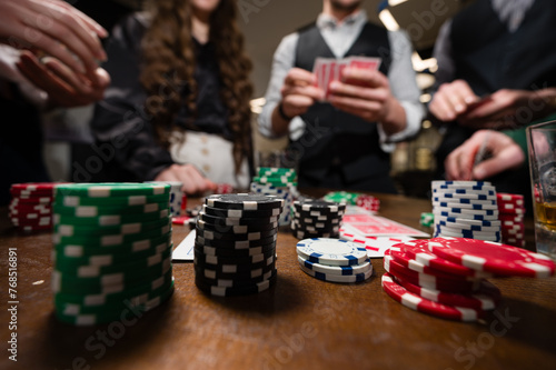 A team of young boys and girls play poker. First-person observation of card poker from various close-up angles.
