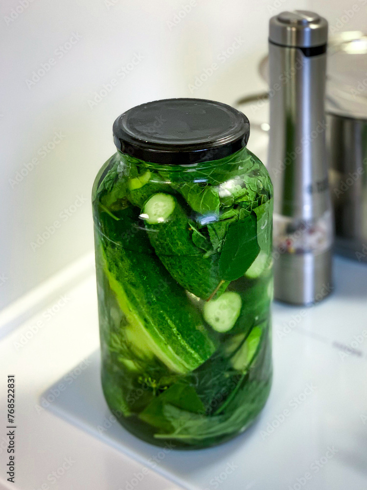 A Mason jar of pickling fluid sits on the countertop