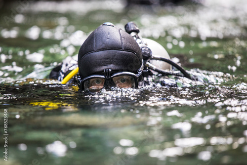 Suba diver surfaces after a dive, goggles protecting eyes photo