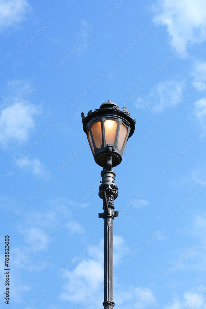 historic street lamp and blue sky. A lantern symbolizing a romantic era in human history