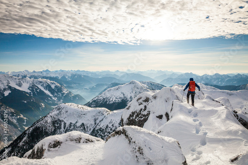 A mountaineer approaches the summit of a mountain in winter photo