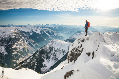 Mountain climber standing on snow covered mountain top