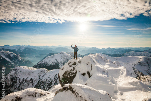 Hiker celebrates after reaching the summit of a mountain photo