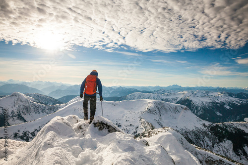 Rear view of successful backpacker standing on mountain summit