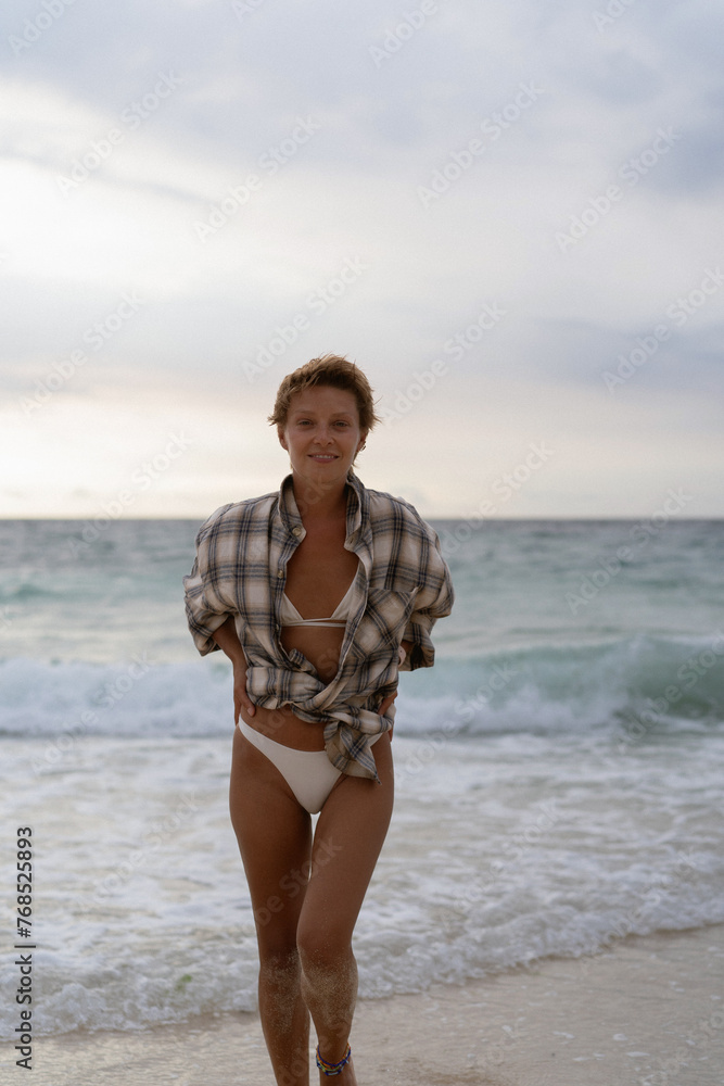 Happy woman with short hair, swimsuit on the beach, emotional. Happy woman with short hair, swimsuit on the beach, emotional.