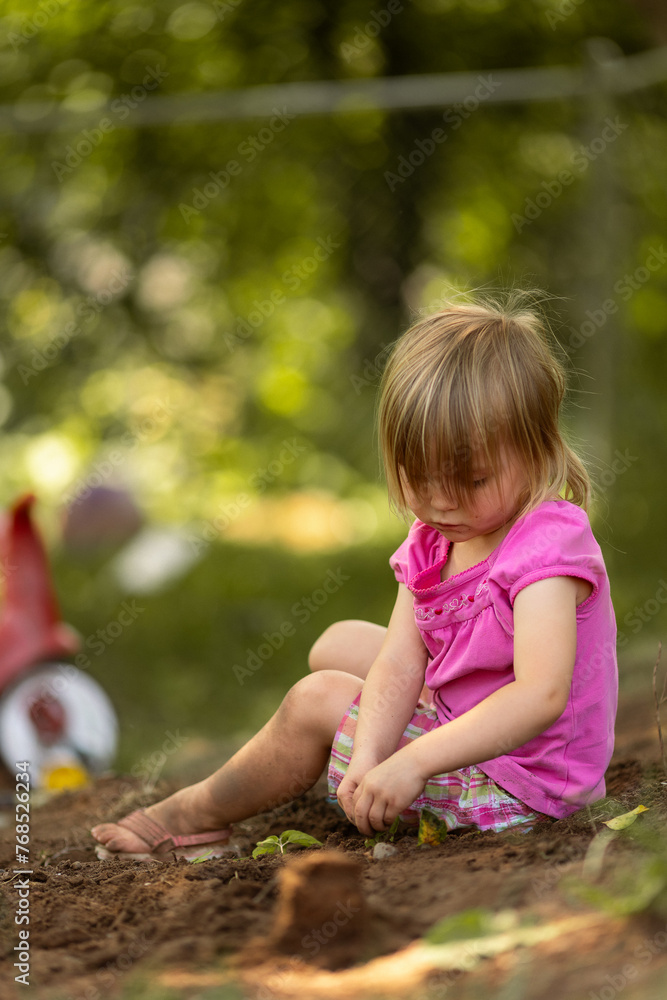 Young girl joyfully playing in the dirt Young girl joyfully playing in the dirt