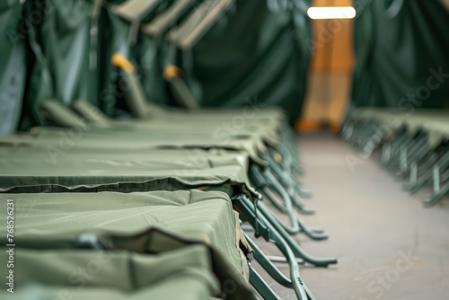 row of empty cots in an organized military tent photo