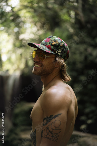 Portrait of a young stylish man traveler in the tropical jungle. photo