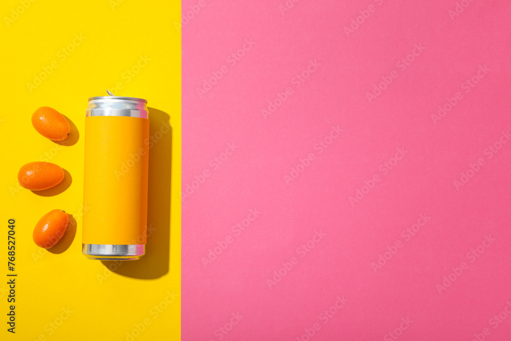 Tin can and kumquats on yellow and pink background, space for text Tin can and kumquats on yellow and pink background, space for text