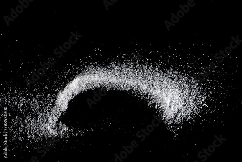 Spilled white sea salt on a black background. clear crystalline pebbles on a black background. Salt explosion.