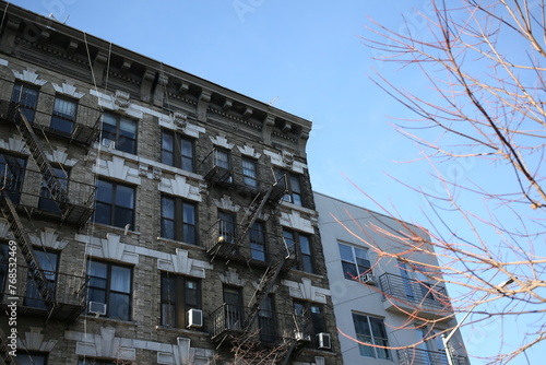 Aged apartment building with a tree nearby.