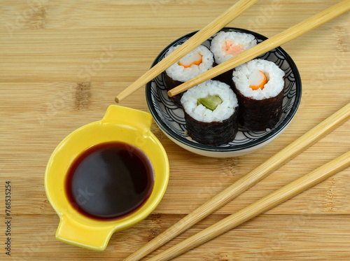 Sushi Set nigiri and sushi rolls on wooden serving board with soy sauce and chopsticks