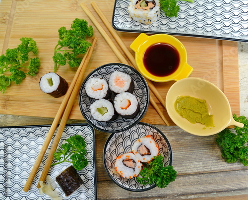 Sushi Set nigiri and sushi rolls on wooden serving board with soy sauce and chopsticks