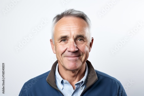 Portrait of a senior man with grey hair and blue shirt.