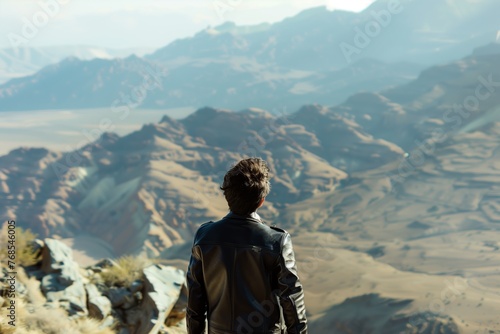 hiker in leather jacket overlooking mountain view