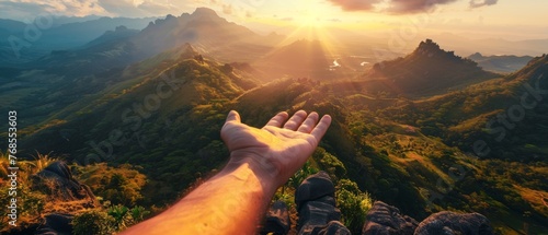 During a beautiful sunrise, a young man reaches for the mountains