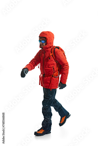Man, tourist wearing warm jacket, goggles and backpack for comfortable mountain climbing isolated on white background. Concept of active lifestyle, tourism, mountaineering, sport, travelling