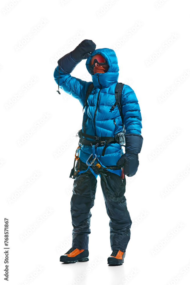 Winter tourism. Man wearing protective goggles, gloves, boots and special equipment for mountain climbing isolated on white background. Concept of active lifestyle, tourism, mountaineering, sport Winter tourism. Man wearing protective goggles, gloves, boots and special equipment for mountain climbing isolated on white background. Concept of active lifestyle, tourism, mountaineering, sport