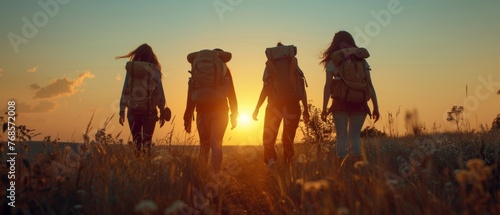 A group of friends walking with backpacks in the sunset. Adventure, travel, tourism, hiking, and friendship concept. Sports activity.