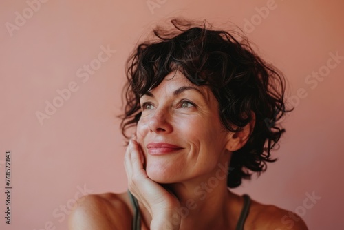 Portrait of a beautiful middle-aged woman on a pink background