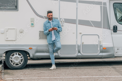attractive traveler man with caravan and mobile phone
