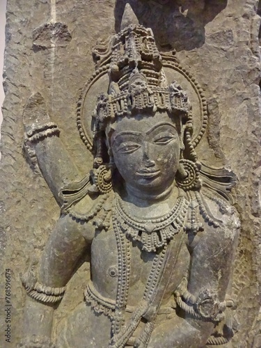 A finely detailed stone sculpture of a Jain Tirthankara Parshwanath statue, with a serene expression, surrounded by ornate carvings photo