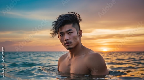 Atrractive handsome asian man in sea shirtless  posing at sunset ocean
