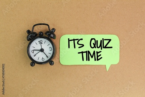 bell and stick clock with the words Its Quiz Time. the concept of answering quizzes or quiz games photo