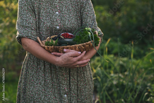 woman harvesting from own vegetable kitchen garden