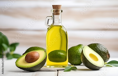 fresh avocado fruit and bottle with avocado oil on white wooden