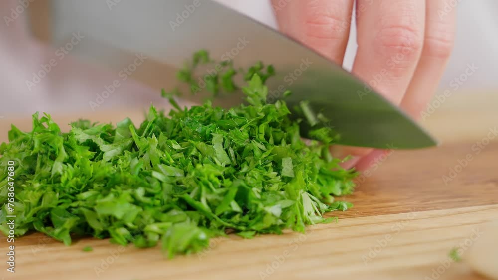 Macro, chef cuts greens, kale, parsley, cilantro with a sharp knife on a wooden board. Healthy eating, home cooking, diet, diet food, vegetarian food. Close-up, front view Macro, chef cuts greens, kale, parsley, cilantro with a sharp knife on a wooden board. Healthy eating, home cooking, diet, diet food, vegetarian food. Close-up, front view