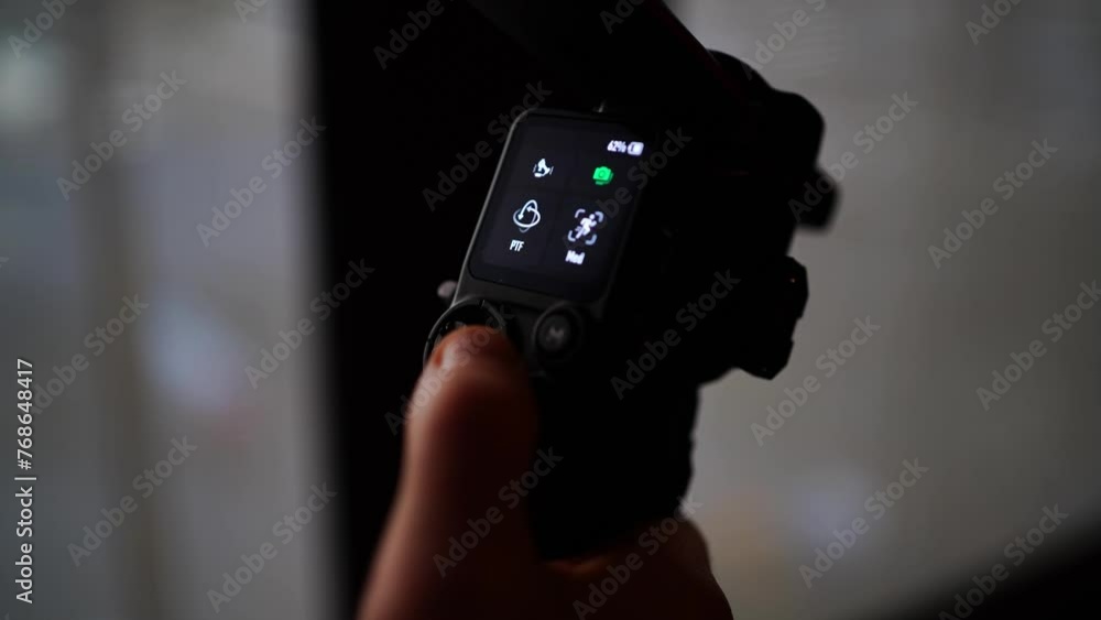 Close up of small gimbal stabilizer screen, person finger push joystick Close up of small gimbal stabilizer screen, person finger push joystick